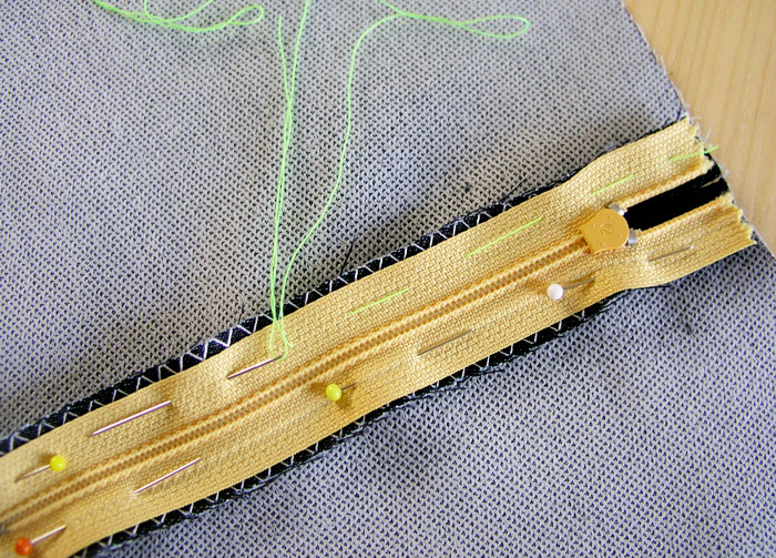 HIlvanar la cinta de la cremallera a los márgenes de costura.